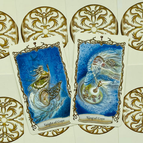 Tarot kortos mėlynoje temoje, matomi Knight of Cups ir King of Cups priekio piešiniai su auksiniais ornamentais
