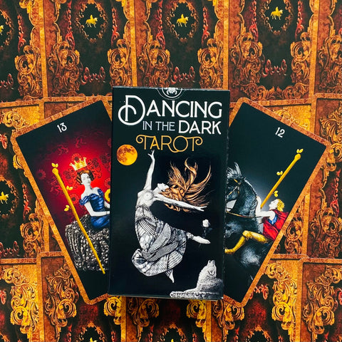 Tarot kortos Dancing in the Dark juoda dėžutė centre su šokėjos iliustracija ir dviejomis atverstomis kortomis