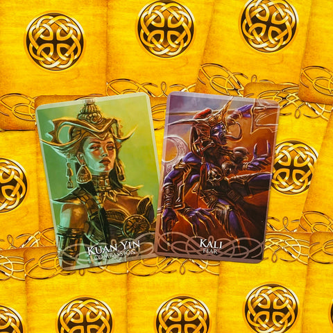 Tarot kortos dvių kortų išklotinė prie auksinio keltų rašto nugarėlių, rodanti Kuan Yin ir Kali piešinius