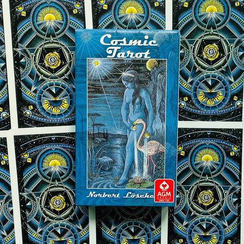Cosmic Tarot mėlyna pakuotė su Norbert Lösche iliustracija ir AGM Urania logotipu ant kortų nugarėlių rašto