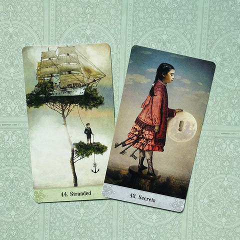 tarot kortos su iliustracijomis: kortos 44 „Stranded“ ir 43 „Secrets“ ant žalsvo ornamentuoto fono, dešinė pakreipta