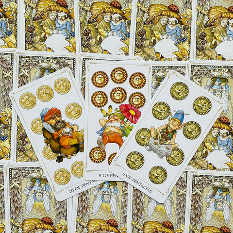 Tarot kortos su auksiniais pentakliais ir nykštukų iliustracijomis, fanuotos 8–10 pentaklių kortos rodo dizaino detales