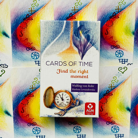 Kortų rinkinys Cards of Time stilinga balta dėžutė su kišeniniu laikrodžiu priekyje, ryškus margas fonas