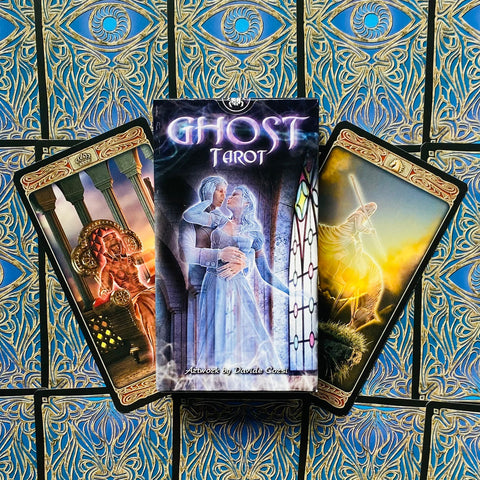 Ghost Tarot kortų rinkinys dėžutėje su vaiduokliškomis iliustracijomis, kortos išskleistos ant mėlyno ir aukso rašto