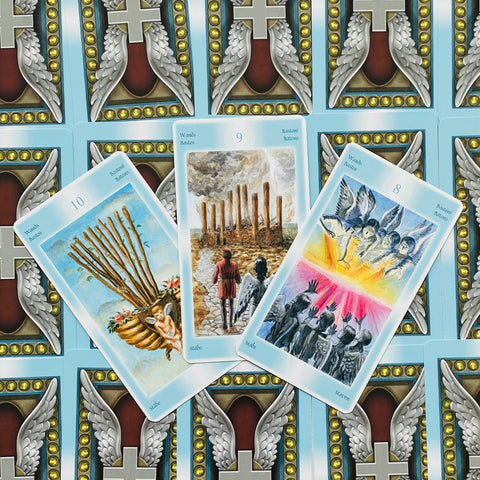 tarot kortos su šviesiai mėlynais nugarėliais, trys atviros lazdelės (8–10) su angelų ir pranašystės motyvais