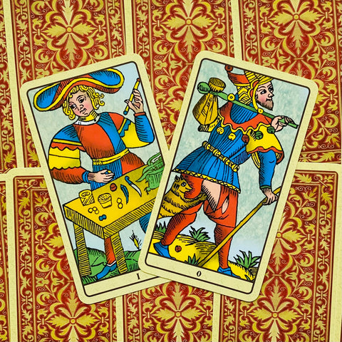 Tarot kortos Marseilles stiliaus, dvi atviros kortos (Kvailys ir Paginė), ryškūs geltoni ir mėlyni piešiniai bei raudonos ornamentinės nugarėlės