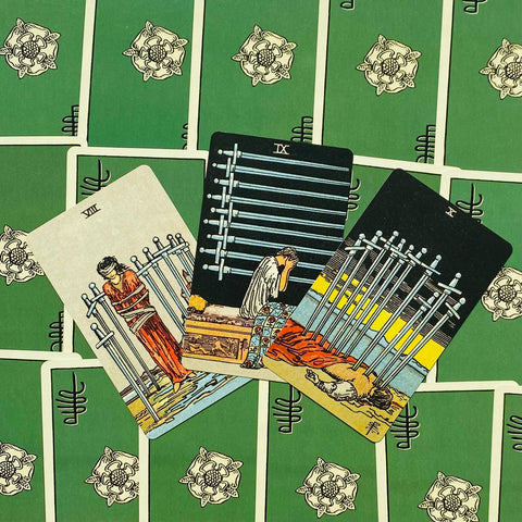 Tarot kortos Rider–Waite, trijų Kardų kortų išklotinė (VIII, IX, X) ant žalios nugarėlės, rodoma kortų variacija