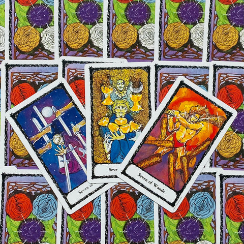 Tarot kortos su trimis atvertomis septynių kortomis, ryškūs akvareliniai piešiniai ir gėlėmis dekoruotos nugarėlės