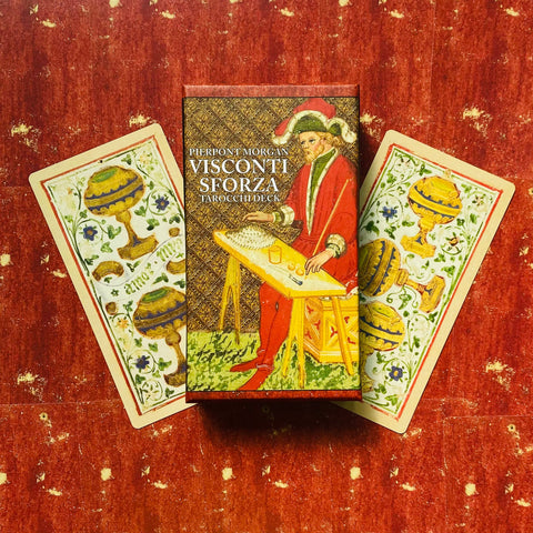 Tarot kortos Visconti Sforza dėžutė su dviem taurės rūšies kortomis išsidėsčiusios ant raudono fono