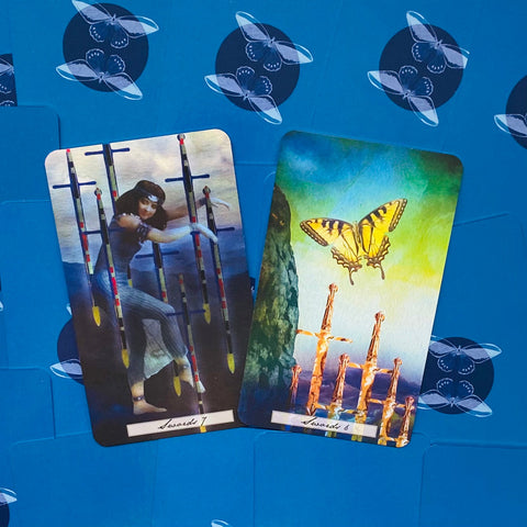 Tarot kortos — dvi versijos (7 ir 6 kalavijų) su geltonu drugeliu ir piešiniu ant ryškaus mėlyno fono
