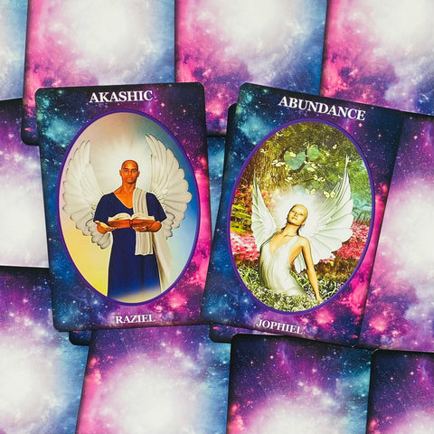angelų kortos su violetiniu kosminiu fonu, matomos Raziel ir Jophiel kortos su baltų sparnų ir sodrių spalvų detalėmis
