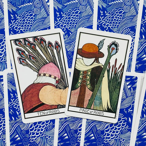 Tarot kortos Rider–Waite stiliaus rinkinys su atverstomis Ten of Rods ir Page of Rods kortomis ant mėlyno nugarėlio