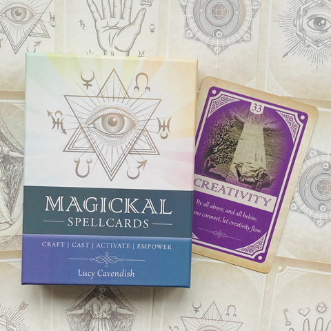 Magickal Spellcards dėžutė su pastelinio dizaino viršeliu ir kampu atidengta violetine Creativity korta, rodanti komplekto turinį