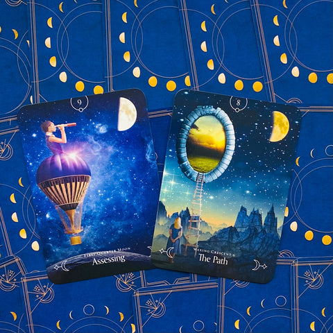 tarot kortos su mėlynu dekoratyviniu užklotu, dvi atverstos kortos — „Assessing“ su purpuriniu oro balionu ir „The Path“ su laiptais į švytintį portalą
