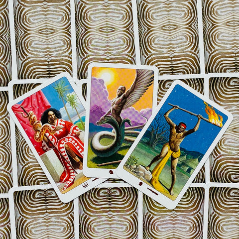 Tarot kortos – trijų atverstų spalvotų kortų kompozicija su afrikietiškais motyvais ir raštuotomis nugarėlėmis