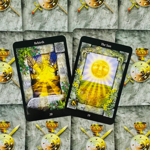 tarot kortos Rebirth (20) ir The Sun (19) su ryškiomis geltonomis saulės motyvomis, dvi atviros kortos pabrėžia variantus