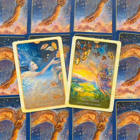 Orakulų kortos, spalvingas artimas planas su dviem atverstomis kortomis Miracles and Blessings ir Have Faith ant mėlynos angelų nugarėlės