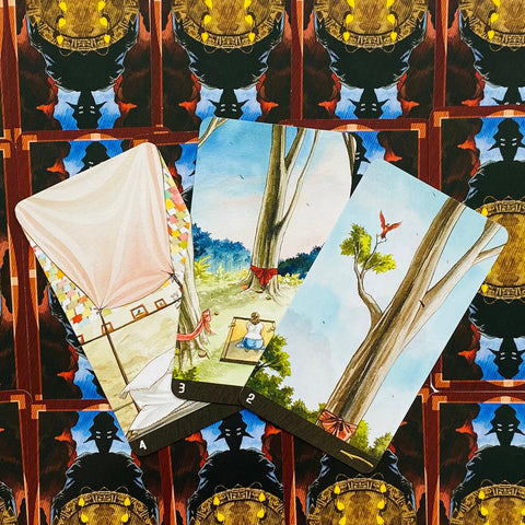 Tarot kortos trijų kortų fane: pastelinių medžių iliustracijos su raudonomis juostelėmis, atvertos ant tamsaus ornamentuoto nugarėlių fono