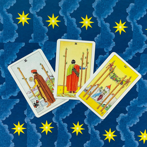 Tarot kortos – trijų Lazdų kortų išdėstymas (II, III, IV) ant mėlyno žvaigždėto fono, kampinis artimas planas