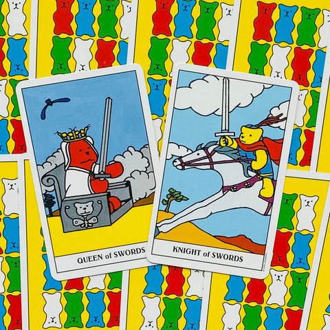 Tarot kortos su spalvota lokių nugarėle: Queen of Swords ir Knight of Swords pasvirusios viena ant kitos, rodo priekį ir nugarėlę