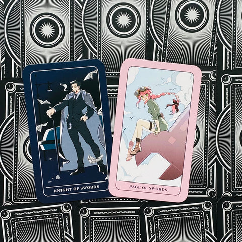 Tarot kortos su mėlynu "Knight of Swords" ir rožiniu "Page of Swords" prie juodų ornamentuotų nugarėlių, parodytos kaip skirtingi priekiniai dizainai