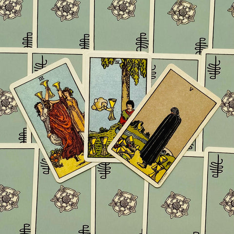 tarot kortos Rider–Waite, trijų kortų išdėstymas ant žalsvų raštuotų nugarėlių, aiškūs spalvoti piešiniai