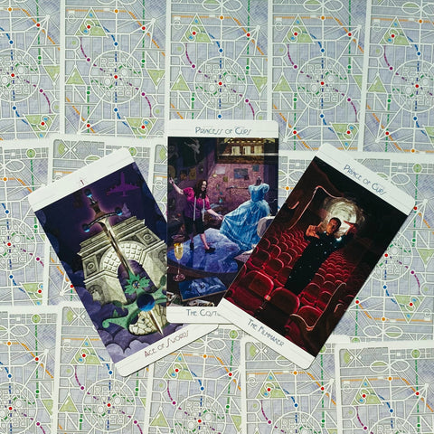Tarot kortos su trimis atverstomis kortomis ant geometriniu raštu padengtų nugarėlių, paruoštos skaitymui