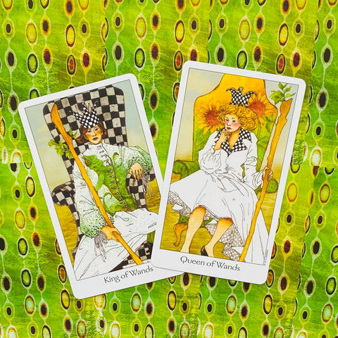 tarot kortos Rider–Waite stiliaus: King of Wands ir Queen of Wands pora, pasvirusios ant žalsvo raštuoto fono, stalčiaus išdėstymas
