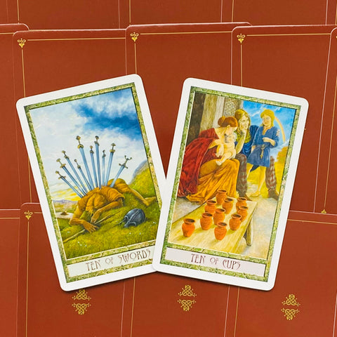 tarot kortos Smith Waite stiliaus rinkinys, dvi atverstos kortos (Ten of Swords ir Ten of Cups) ant raudonų nugarėlių fono