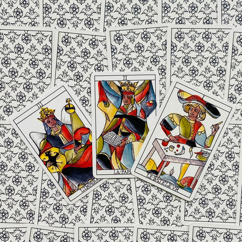 tarot kortos spalvotos Marseille stiliaus, trys atvertos didžiųjų arkanų kortos padėtos ant raštuotų nugarėlių