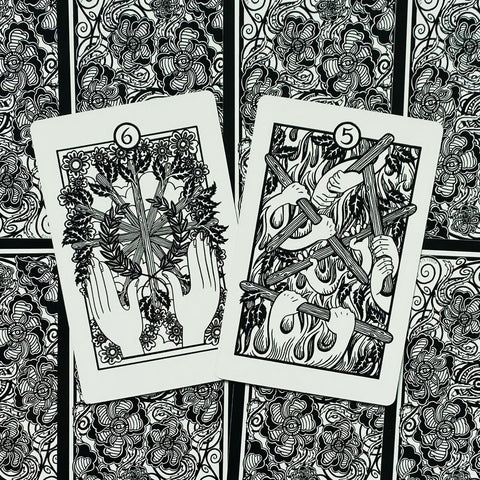 Tarot kortos juodai baltos, dvi atidengtos kortos – 6 vainikas ir 5 lazdos, gėlių nugarėlė