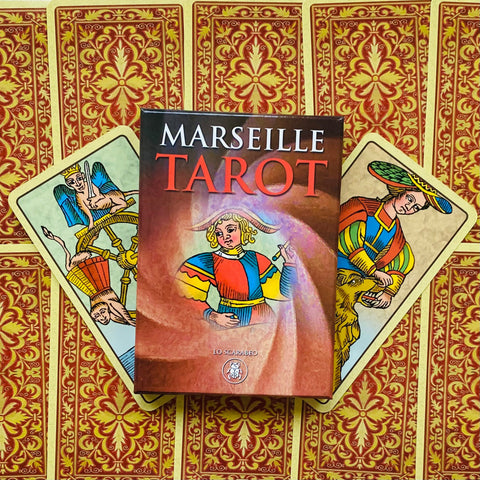 Marseille tarot kortų rinkinys Lo Scarabeo dėžutė ant raudonai auksinių kortų nugarėlių, dvi kortos ištiestos kampu