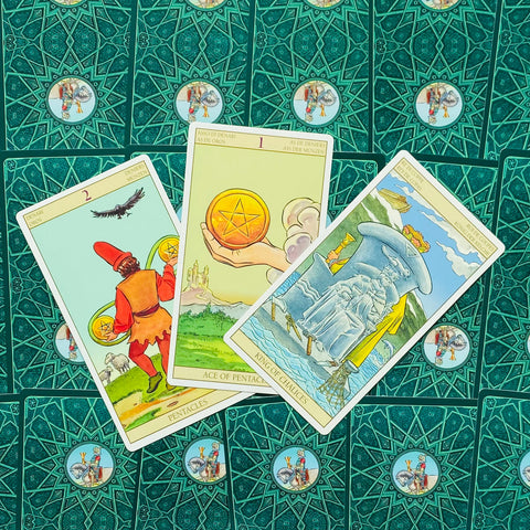 Tarot kortos su ornamentuotomis nugarėlėmis, trijų kortų variantas — Pentaklių tūzas centre; 2 pentakliai kairėje; apverstas puodelių karalius dešinėje