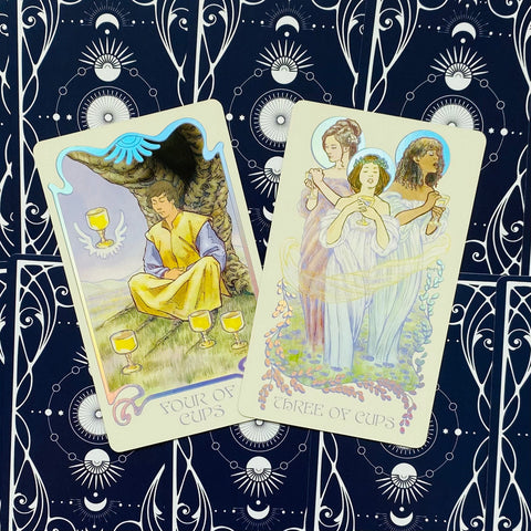 Tarot kortos su keturių taurų ir trijų taurų kortomis, pastelinių spalvų iliustracijos, dvi perklotos kampu ant tamsiai mėlyno žvaigždėto fono