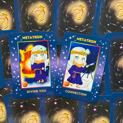 Metatron kortos su dviem atvertais mėlynais kortelėmis „Divine You“ ir „Connection“ ant žvaigždėto fono