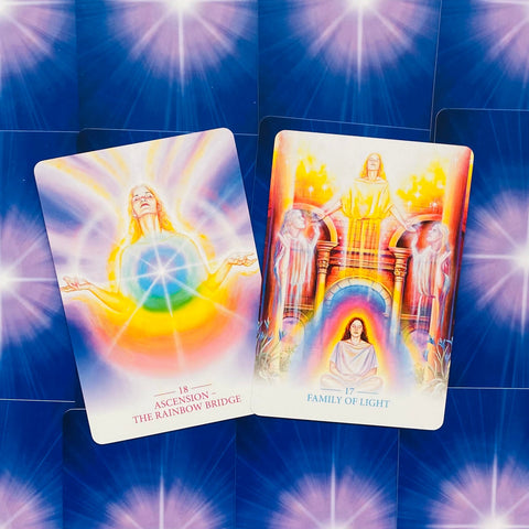 Tarot kortos, dvi atverstos — Ascension ir Family of Light su ryškiomis vaivorykštės spalvomis ir mėlynu galiniu raštu