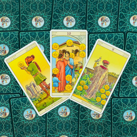 Tarot kortos Rider–Waite stiliaus: trys Pentaklių kortos išdėstytos ant žalsvai turkio raštuotų nugarėlių