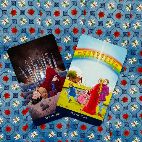 tarot kortos Ten of Swords išversta ir Ten of Cups ant mėlyno fono su raudonomis rožėmis, dvi kortos komplekte