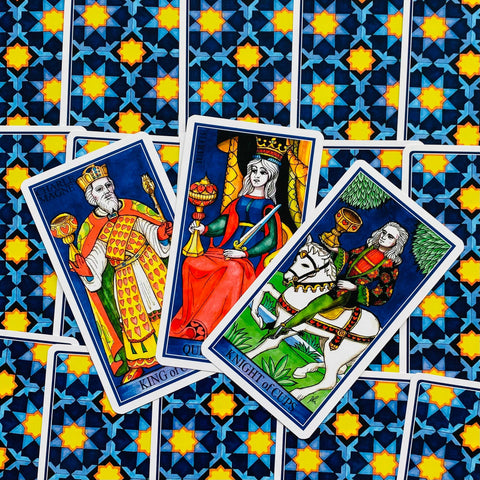 Tarot kortos — spalvotas RWS stiliaus rinkinys: trys atverstos karališkosios kortos ant mėlyno raštuoto nugarėlių fono