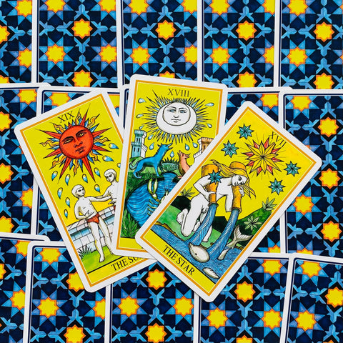 Tarot kortos trijų didžiųjų arkana rinkinyje – Saulė, Mėnulis ir Žvaigždė ant mėlyno raštuoto nugarėlių fono