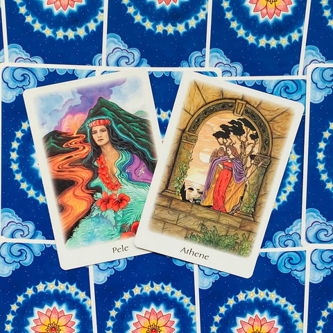 Tarot kortos Pele ir Athene prie mėlyno žvaigždėto mandalos fono, dvi persidengiančios kortos parodytos iš viršaus