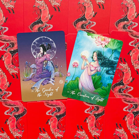 tarot kortos, dvi iliustruotos didelės kortos — mėlynos nakties figūros ir žalios šviesos figūros priekiai ant raudonų nugarėlių su lapių raštu