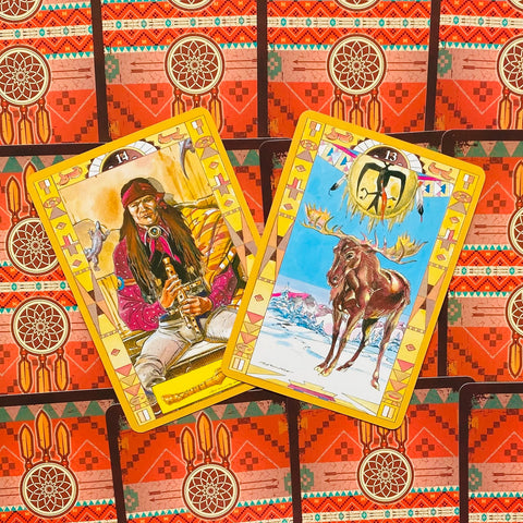 Tarot kortos su geltonais rėmeliais: dvi atverstos kortos su indiškais piešiniais ant raštuoto raudono fono, viena šiek tiek uždengta