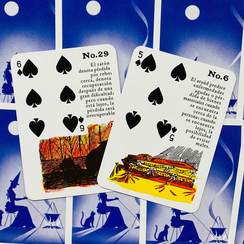 Kortos lenormand stiliaus, dvi atverstos kortos su juodais pikų simboliais ir ryškiais iliustratyviais piešiniais ant mėlynų nugarėlių fono