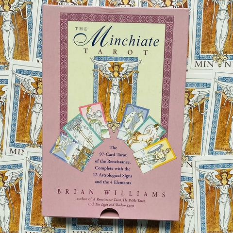 Minchiate tarot kortų rinkinys Brian Williams rožinėje dėžutėje, matomas iš priekio su keliais kortų pavyzdžiais fone