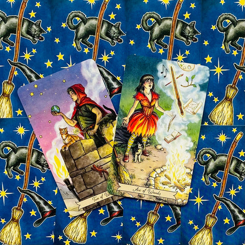 Tarot kortos, iliustruotas rinkinys su Dvejetu lazdų ir Lazdų tūzu ant mėlyno žvaigždėto šluotų fono, priekinis kampas