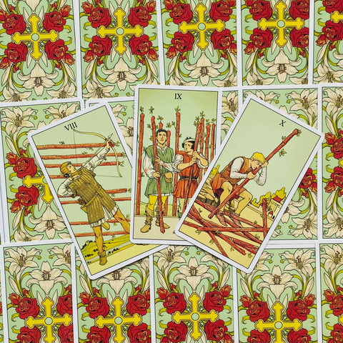 Tarot kortos vintage stiliaus, žalių gėlių nugarėlių, trys atverstos lazdų kortos (VIII, IX, X) centre