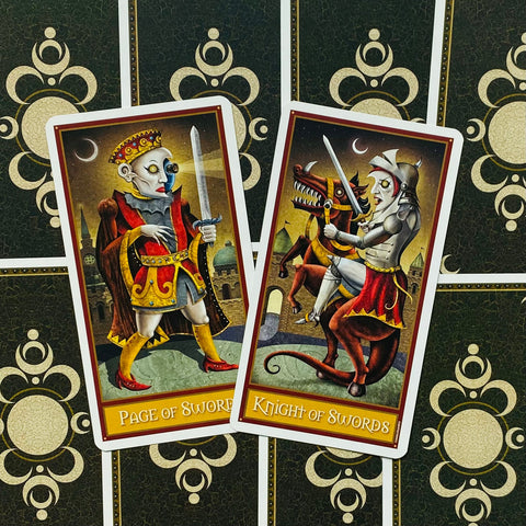 Tarot kortos, dvi Sword serijos kortos (Page of Swords ir Knight of Swords) ant tamsiai žalio raštuoto nugarėlio, pasuktos kampu