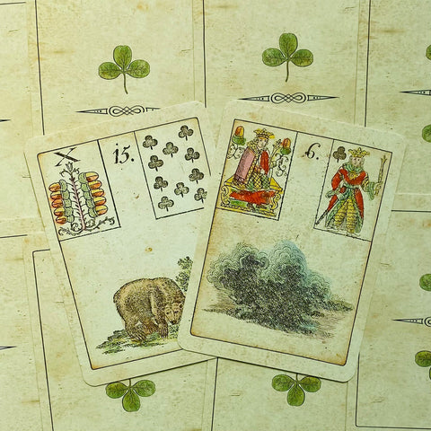 Lenormand kortos, vintage kreminės su žalio dobilėlio averse, dvi išskleistos kortos (Lokys ir Debesys) parodytos persidengiantios ir senovinio stiliaus detalėms pabrėžti
