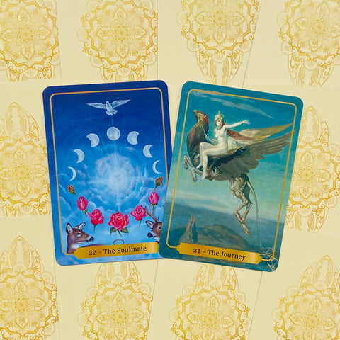 tarot kortos su ryškiomis mėlynomis iliustracijomis — kortos 22 The Soulmate su rožėmis ir 21 The Journey su sparnuotu žvėrimi